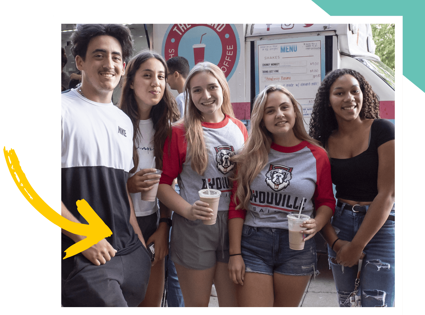 Students holding coffee smiling at the camera.
